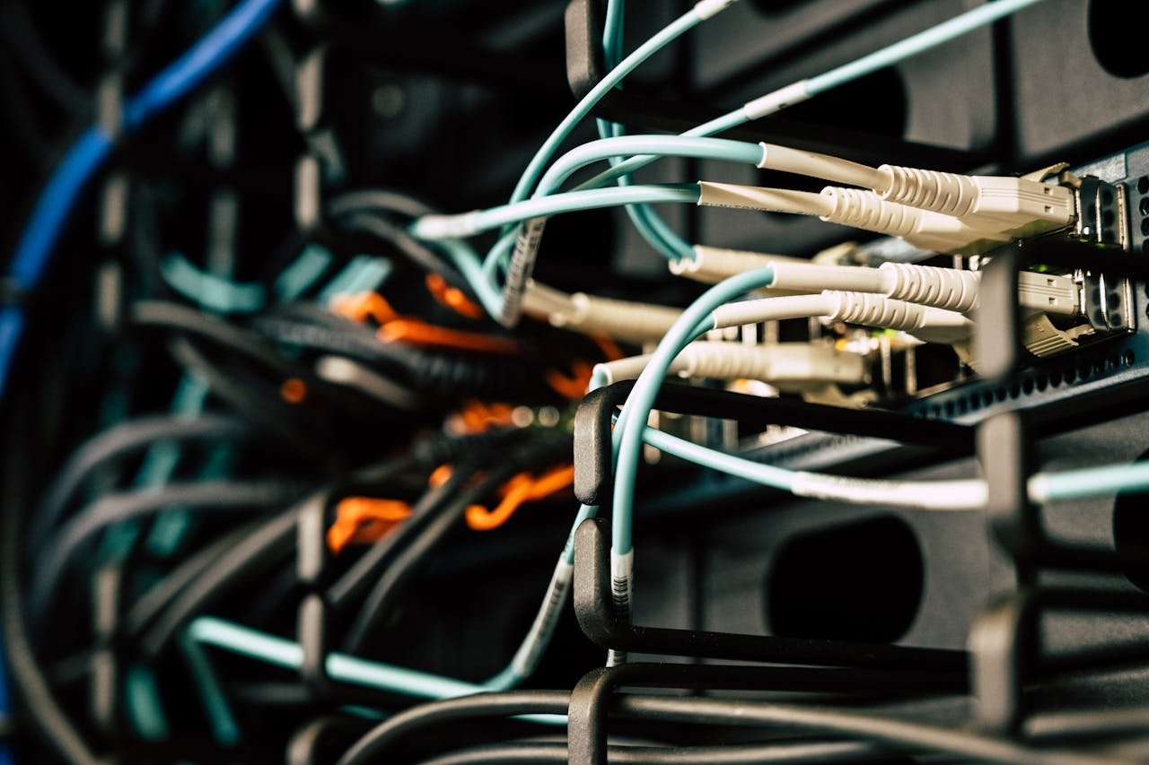 Services Various tangled wires connected to system near black metal cases in server room